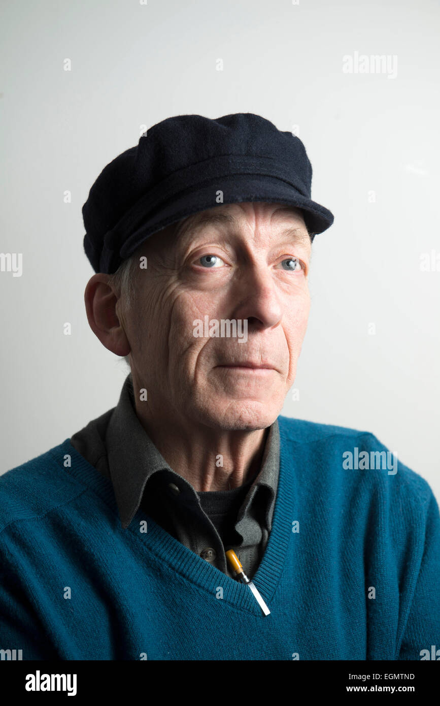 Drôle de caractère vieux sage homme âgé a atteint un sommet dans un chapeau, col en v pull sweater jumper, avec des stylos à l'image d'un mad professor Banque D'Images