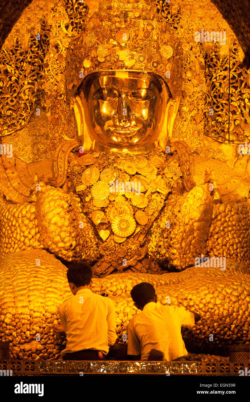 L'application de la feuille d'or hommes bouddhistes gilt à l'image du Bouddha Mahamuni, temple du Bouddha Mahamuni, Mandalay, Myanmar ( Birmanie ), l'Asie Banque D'Images