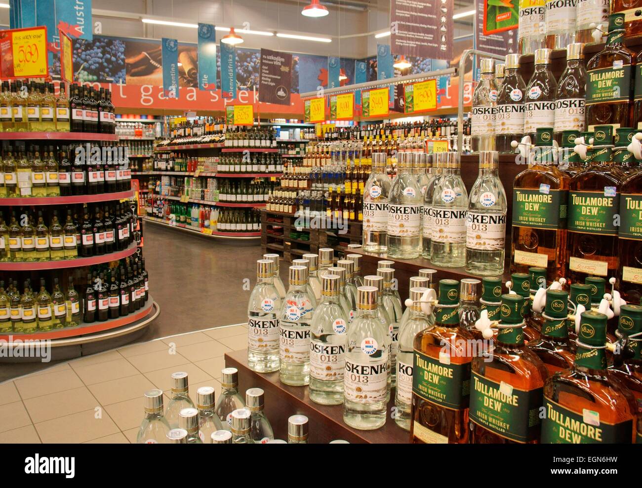 Riga Lettonie. Centre-ville nord hypermarché Rimi store. Affiche de l'allée de supermarché. L'alcool, vodka, whisky spirit les ventes de bouteilles Banque D'Images