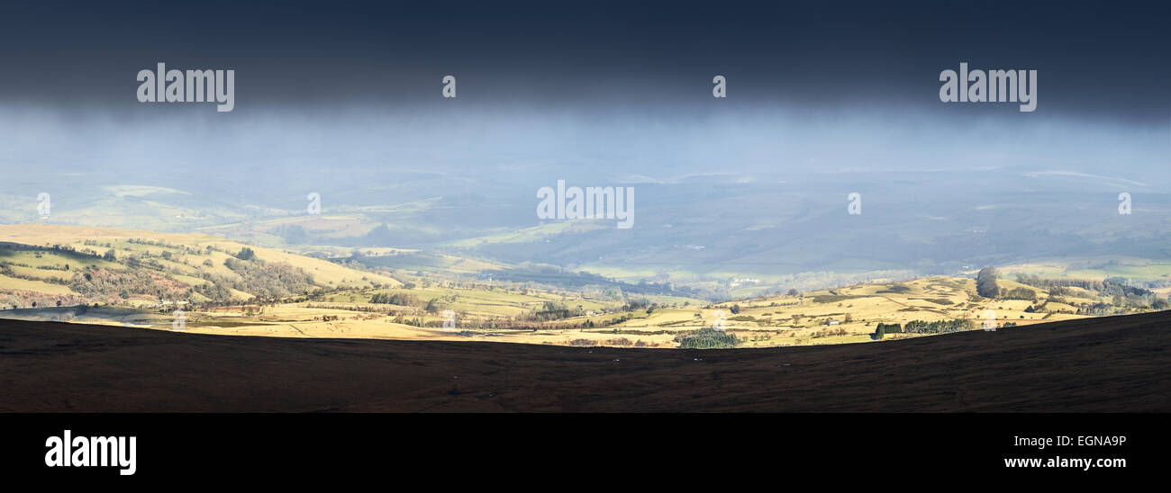 La lumière du soleil qui brille à travers les vallées de juste en dessous de la base du nuage près du sommet du Pen Y Fan mountain dans les Brecon Beacons. Banque D'Images