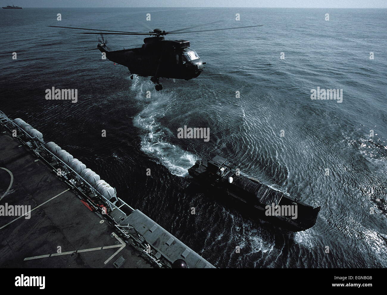 AJAXNETPHOTO. (OMA-84). 6 OCT 2001. L'OMAN. - Soulever - RNAS Hélicoptère Sea King se décolle de la PLATE-FORME DU HMS FEARLESS COMME L'UNE DES PROVISIONS DE TRAINS ROUTIERS VIENT DANS D'AMARRER AUX CÔTÉS DE SAIF SAREEA PENDANT L'EXERCICE EN OMAN. PHOTO:JONATHAN EASTLAND/AJAX. REF:CDSS03/14. Banque D'Images