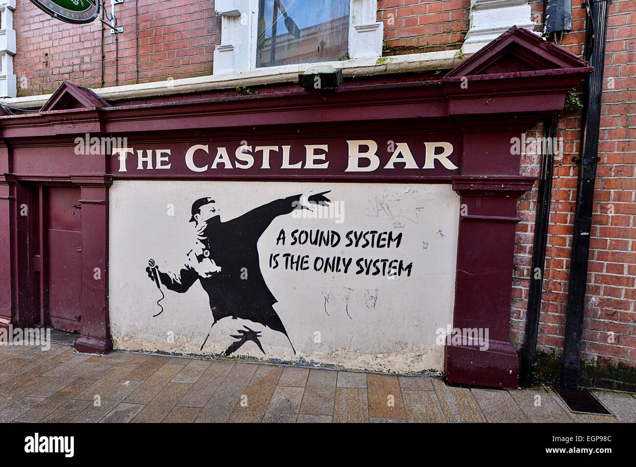 Mur peint avec pub style Banksy art ; l'homme de jeter un microphone, Castle Bar, Derry, Londonderry, en Irlande du Nord. © Geo Banque D'Images