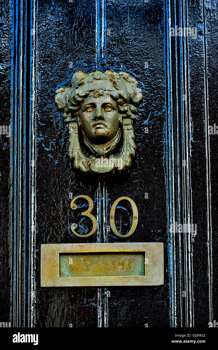 De style géorgien heurtoir en laiton représentant tête humaine avec lettre fort sur noir porte peinte, Londonderry, Derry, dans le Nord de l'IRELA Banque D'Images