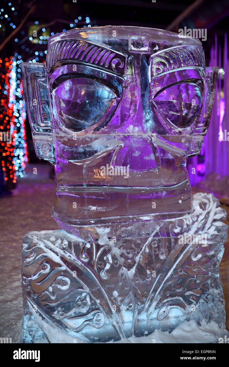 Grande sculpture de glace aux yeux violets avec des lumières à Yorkville Village Park 10e Icefest Cumberland Toronto street at night Banque D'Images