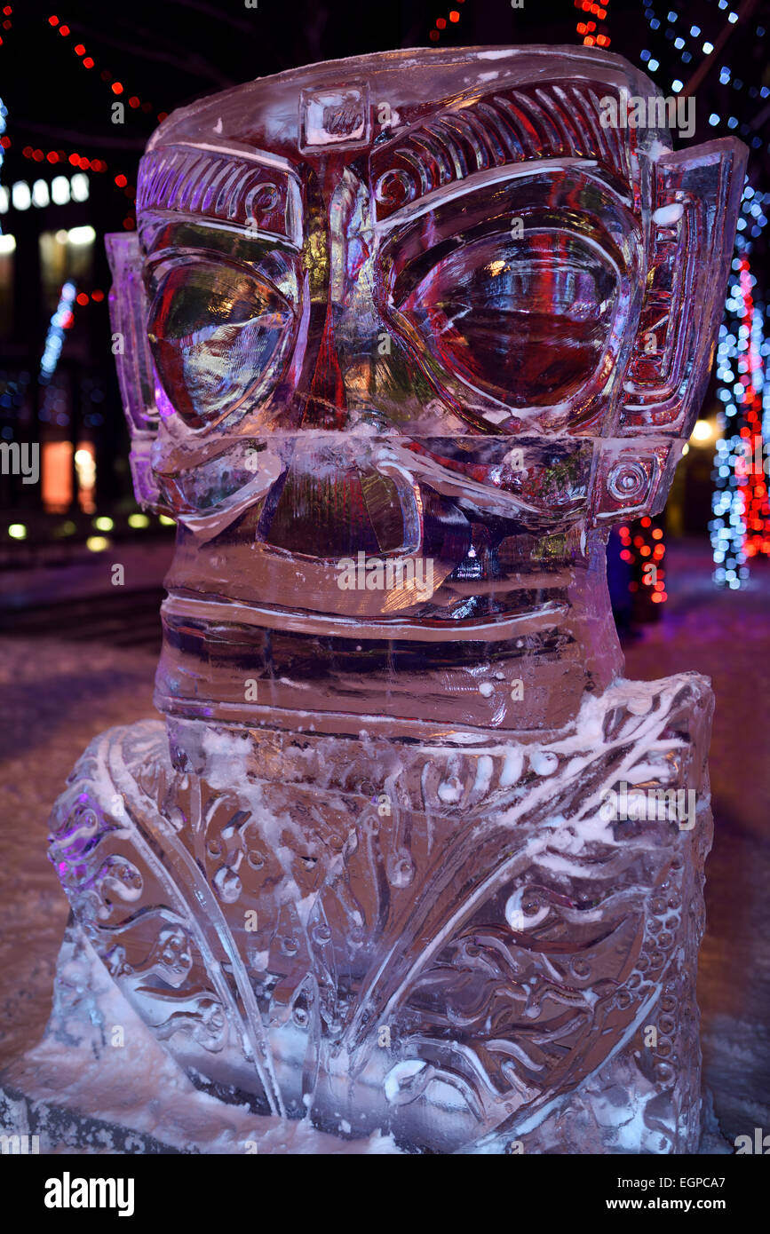 Grande sculpture de glace aux yeux bleus à Bloor Yorkville Village Park 10e Icefest Cumberland Toronto street at night Banque D'Images