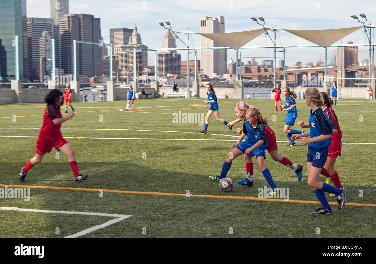 Les filles jouent au football sur les terrains de football de Brooklyn Bridge Park à New York. Banque D'Images