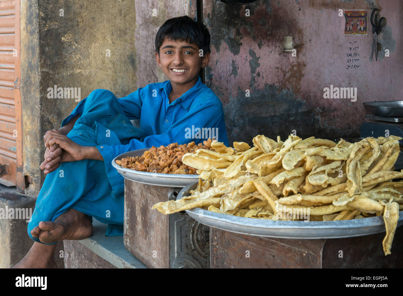 Dans le bazar d'un village, un garçon vend des boulettes sur la rue. Banque D'Images