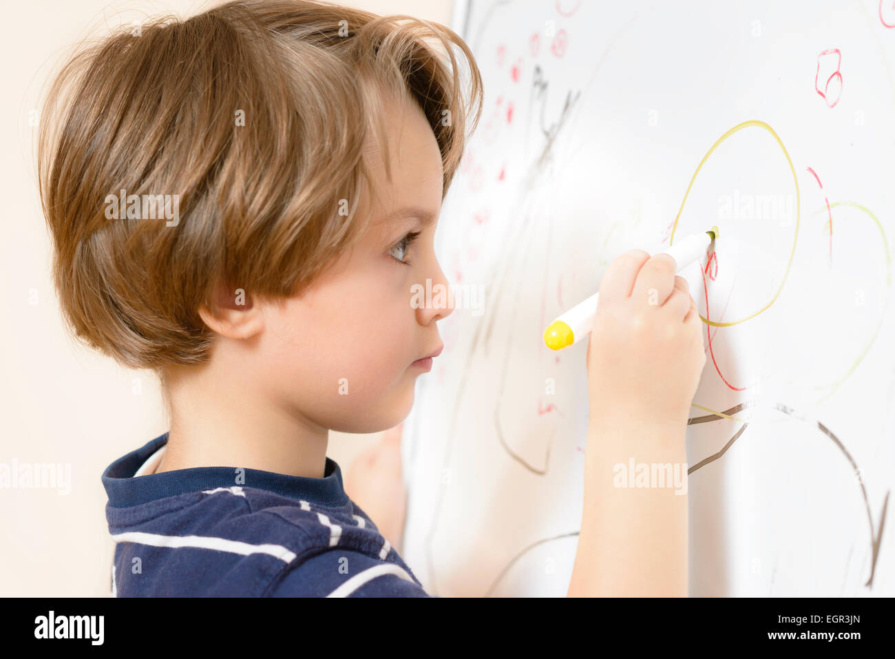 Cute boy dessin à l'école maternelle sur un tableau blanc Banque D'Images