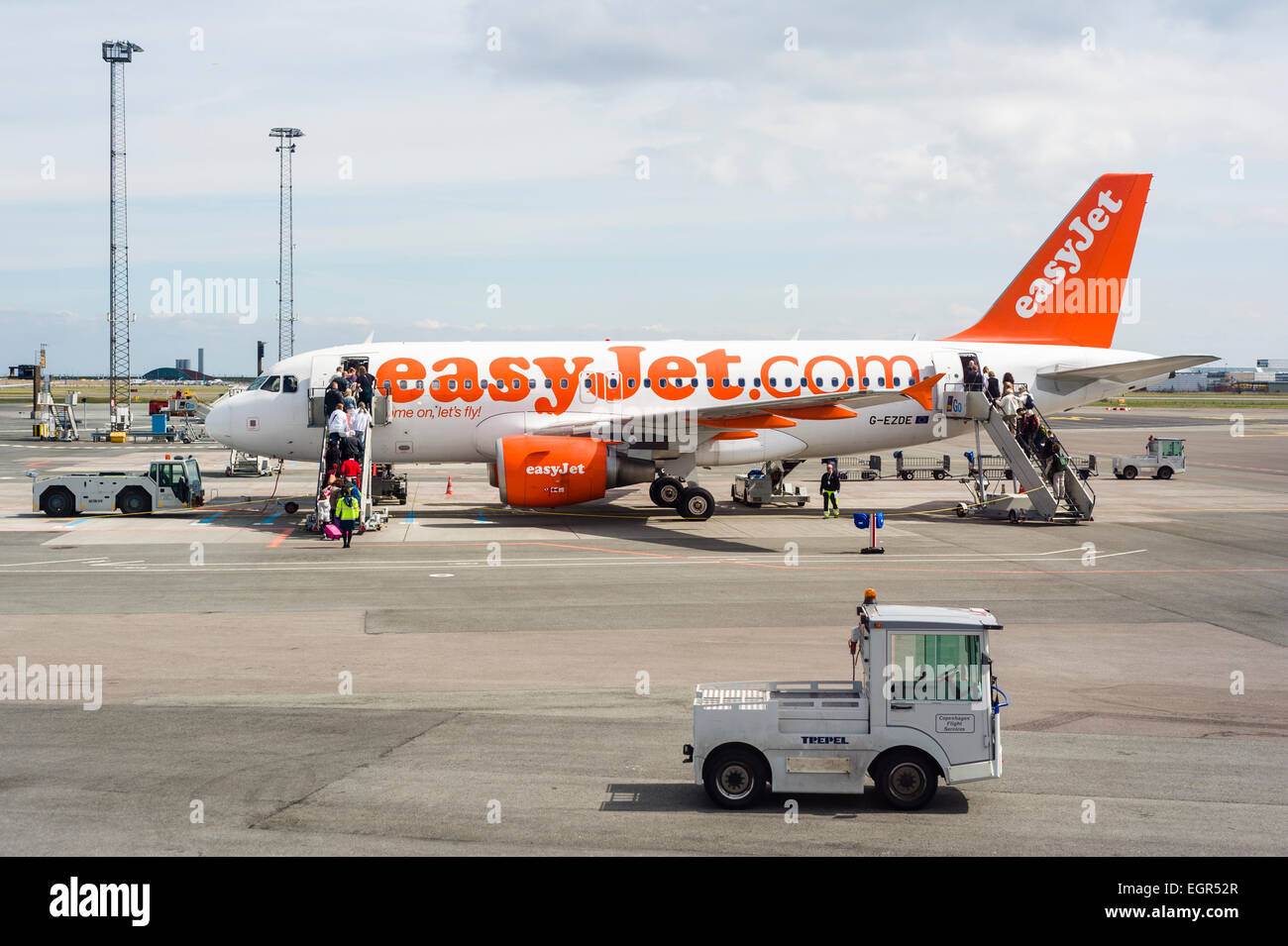 Les derniers passagers bordant un avion easyJet à l'aéroport de Copenhague, avec le personnel au sol de la préparation pour le décollage. Banque D'Images