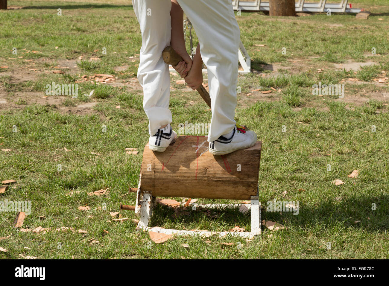 Une photographie d'un homme anonyme vêtu de blanc et participer à un concours en bois massif en Australie. Banque D'Images