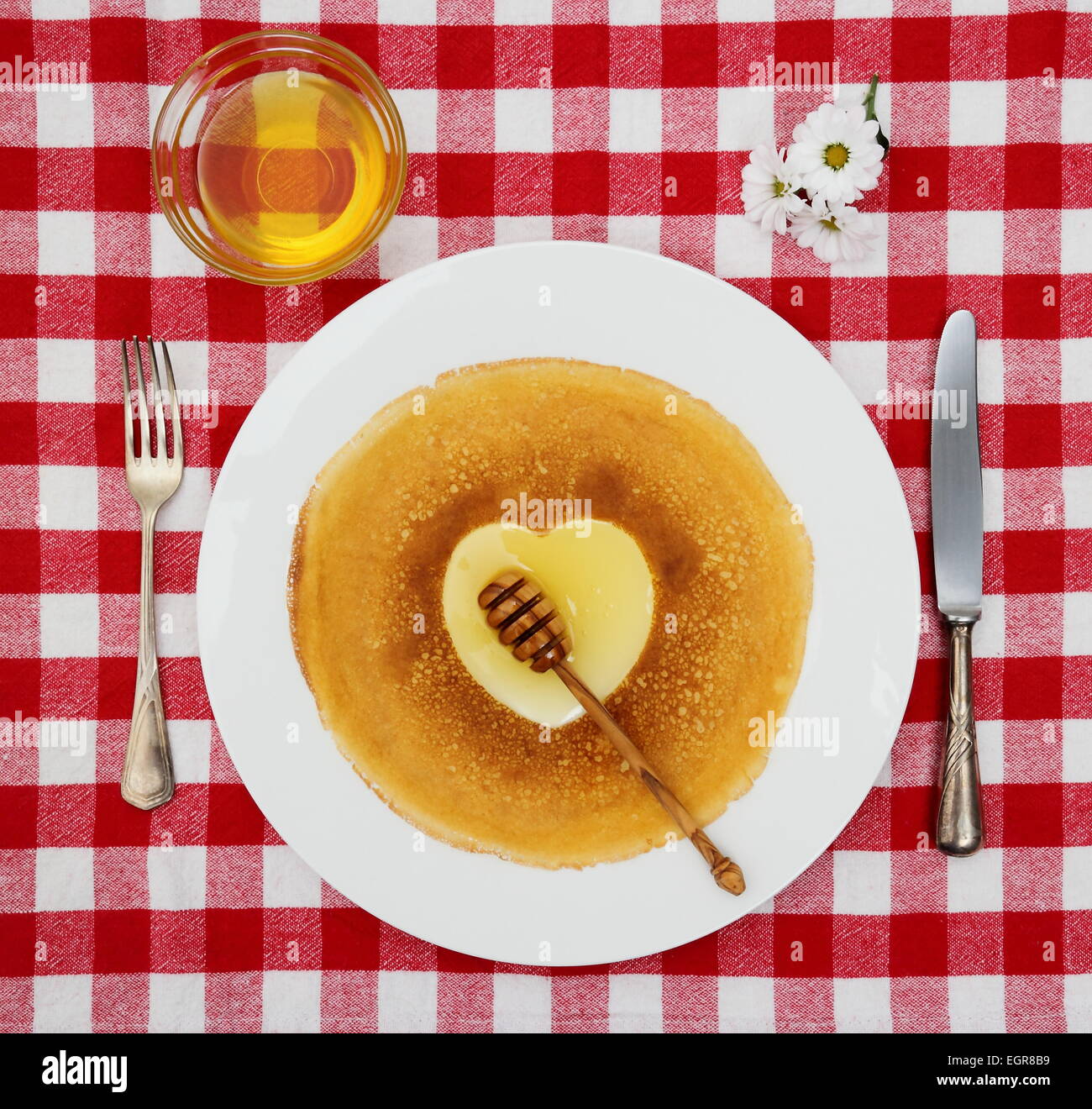 Coeur des crêpes avec honeyflower et couverts, vue d'en haut Banque D'Images