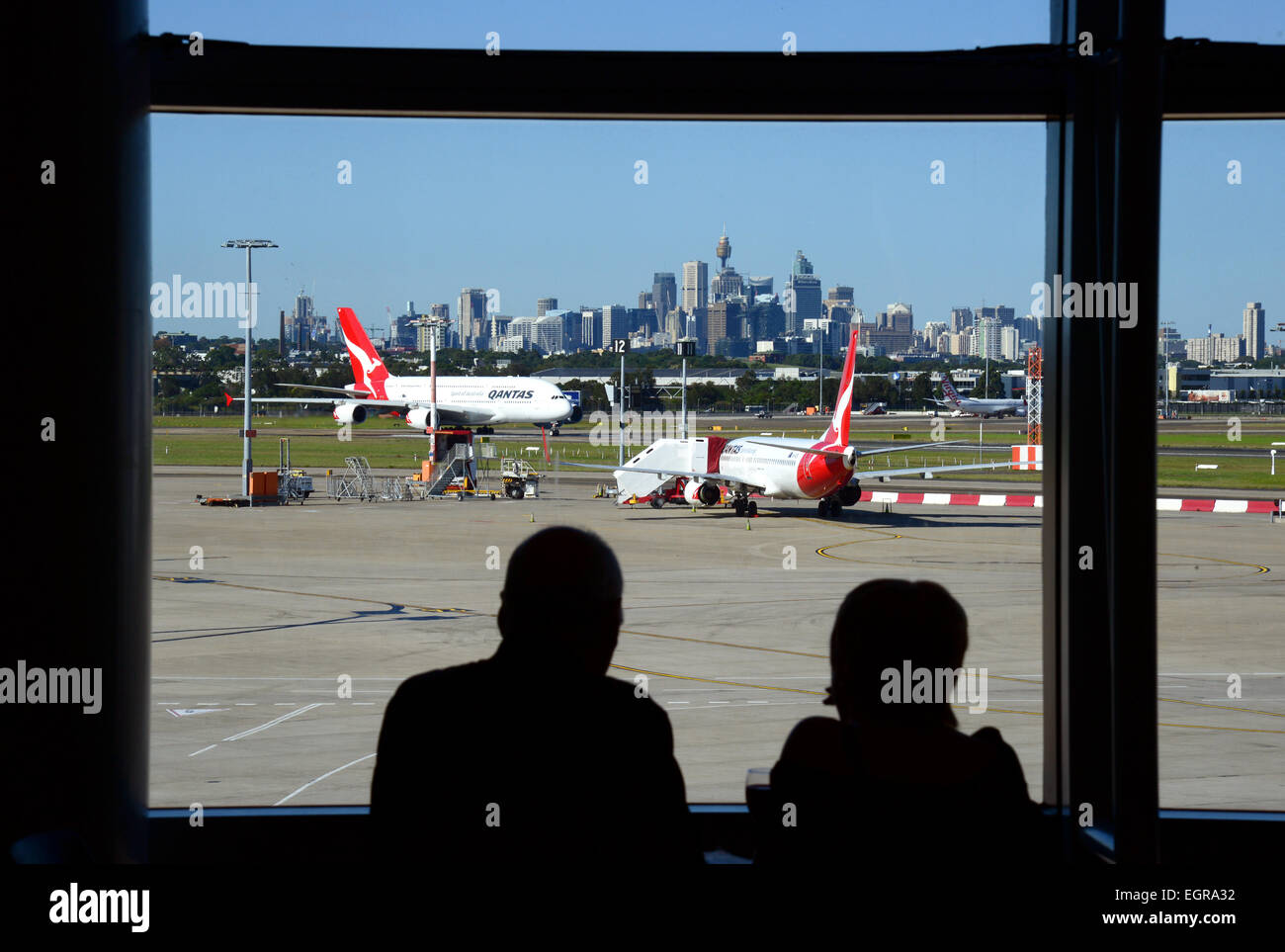 Vue sur l'aéroport de Sydney montrant l'horizon de la ville à partir de la salle d'embarquement, Sydney, Australie. Banque D'Images