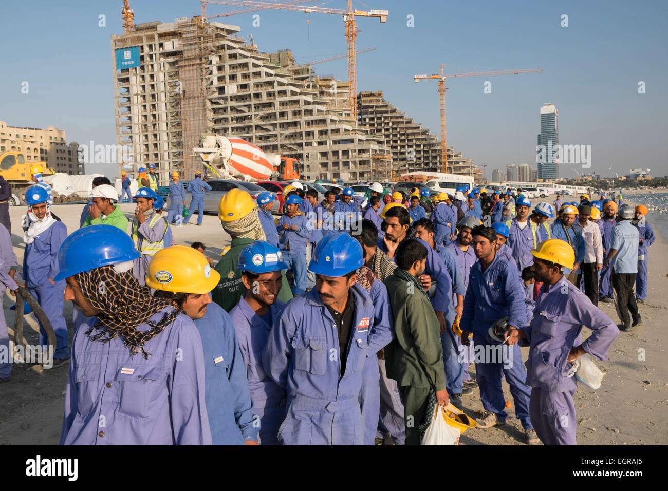 Les travailleurs de la construction d'attente afin de prendre le bus pour le logement à la fin de la journée de travail à Dubaï Émirats Arabes Unis Banque D'Images