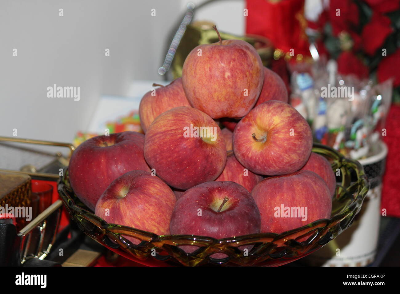 Bol en verre décoratif plein de pommes de couleur rougeâtre Banque D'Images