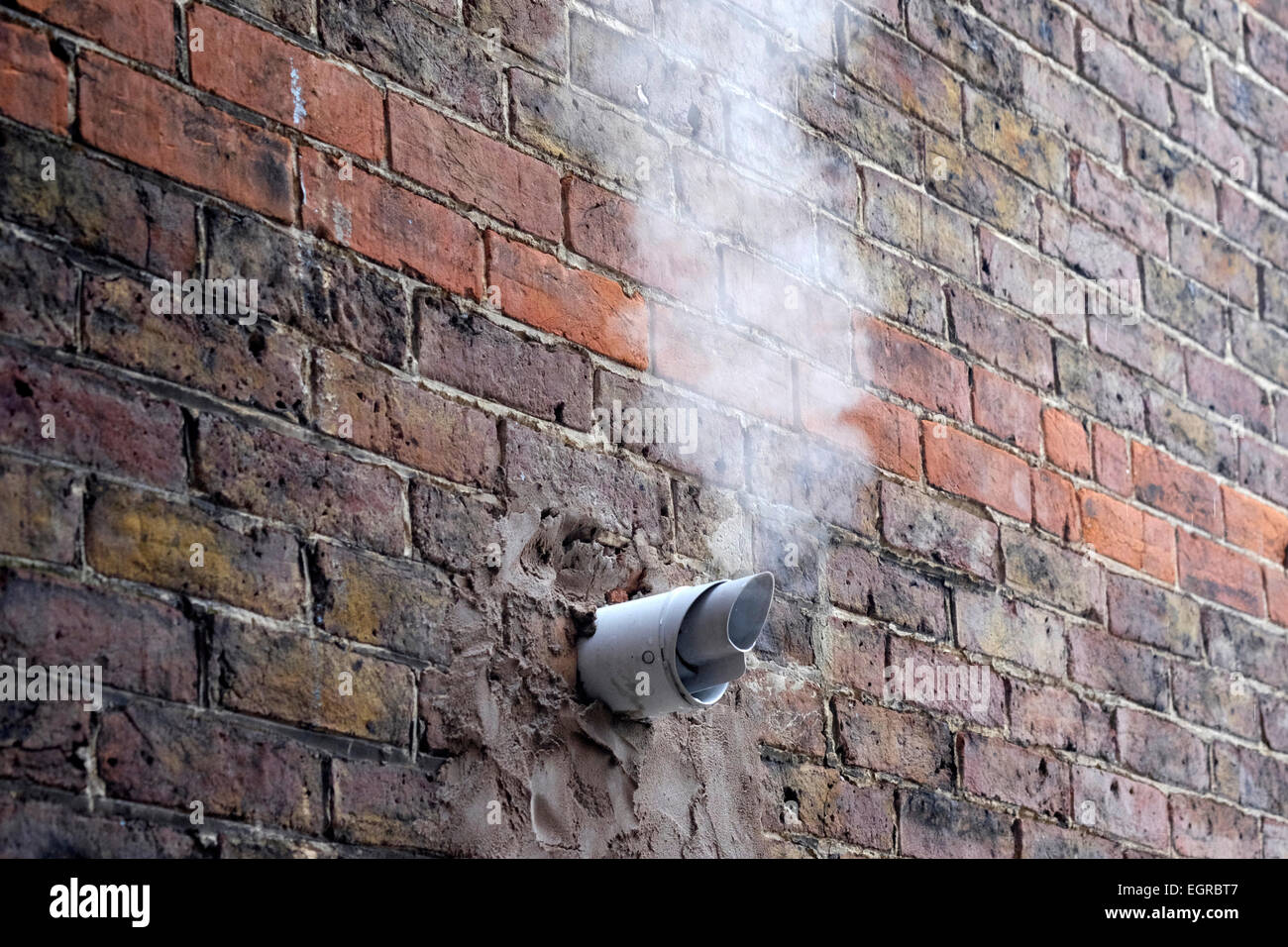 Les gaz d'échappement à partir de la chaudière à gaz émanant de tuyau dans mur de la maison sur une journée froide Banque D'Images