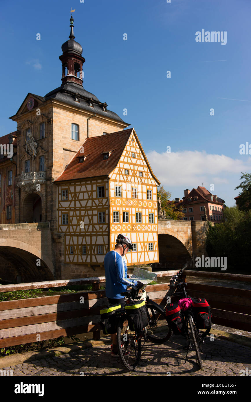 Vérifie son cycliste carte en face de la vieille ville de Bamberg Hall (Altes Rathaus), construit en 1462. Banque D'Images
