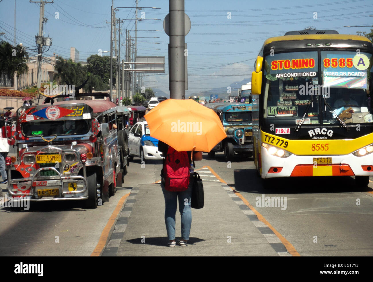 Une philippine attend un véhicule d'utilité publique sous l'ombre de son parapluie Commonwealth Avenue. © Richard James Mendoza/Pacific Press/Alamy Live News Banque D'Images