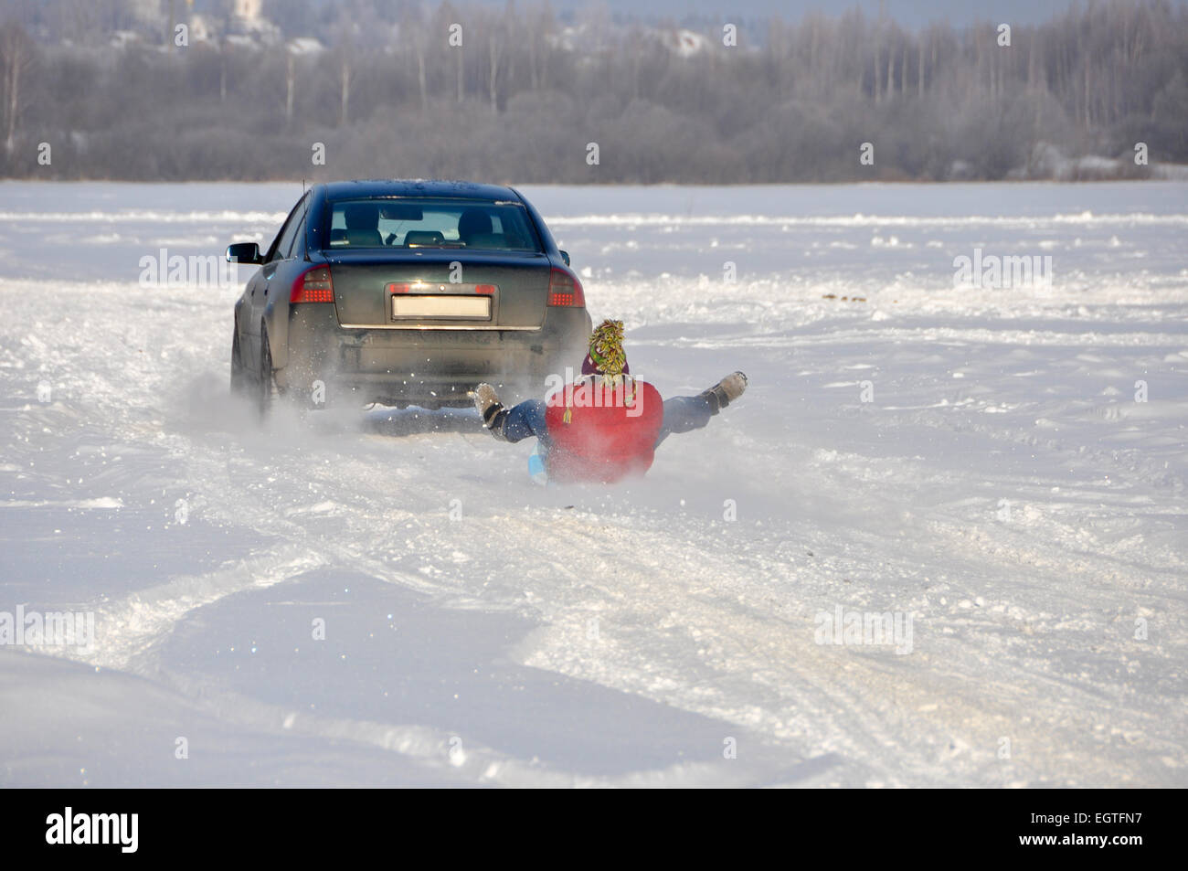 La voiture transportant l'homme sur la glace-bateau en remorque dans la neige Banque D'Images