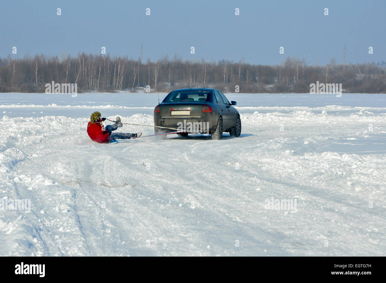 La voiture transportant l'homme sur la glace-bateau en remorque dans la neige Banque D'Images
