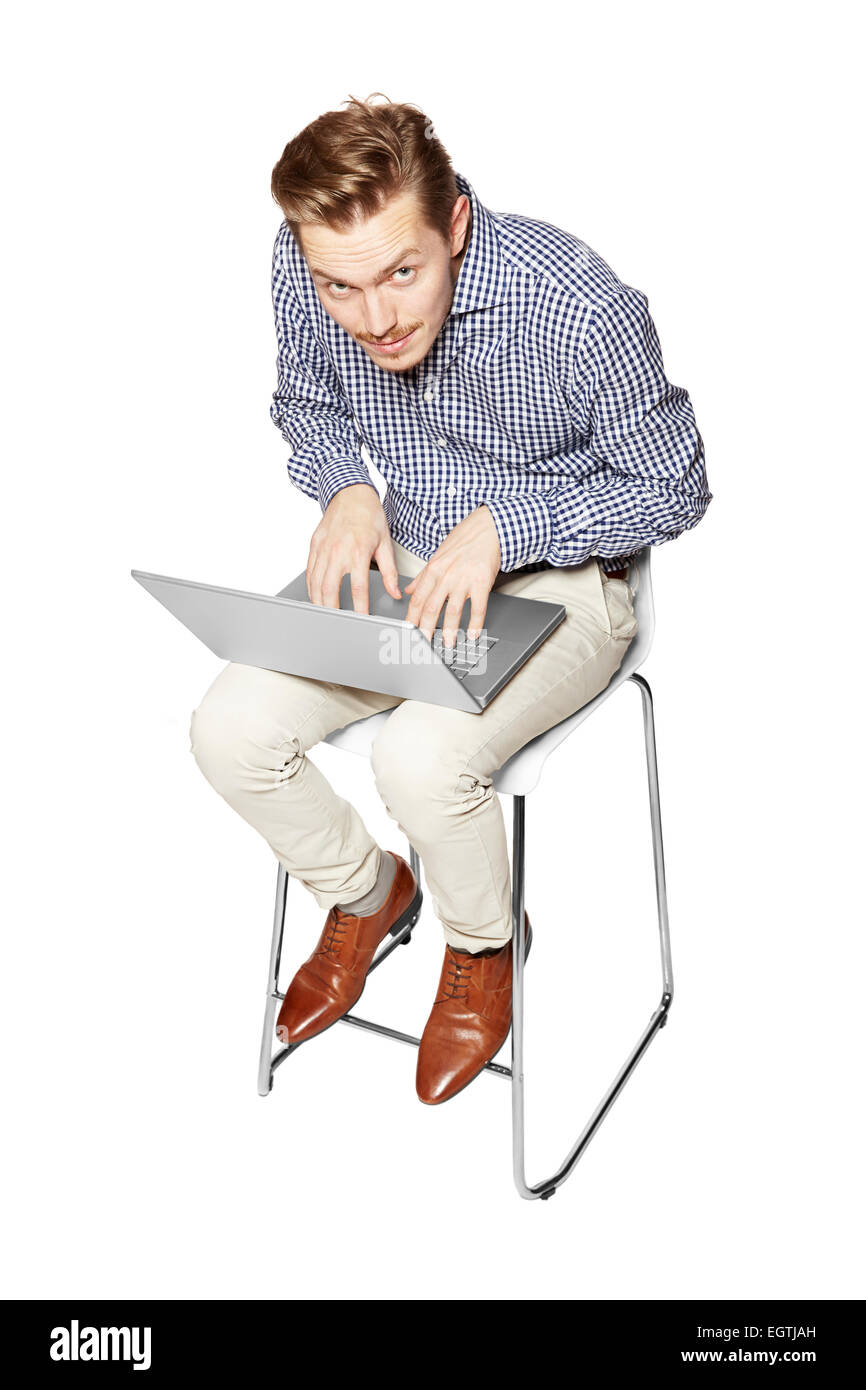 Jeune homme penché sur le clavier sur les genoux. Banque D'Images