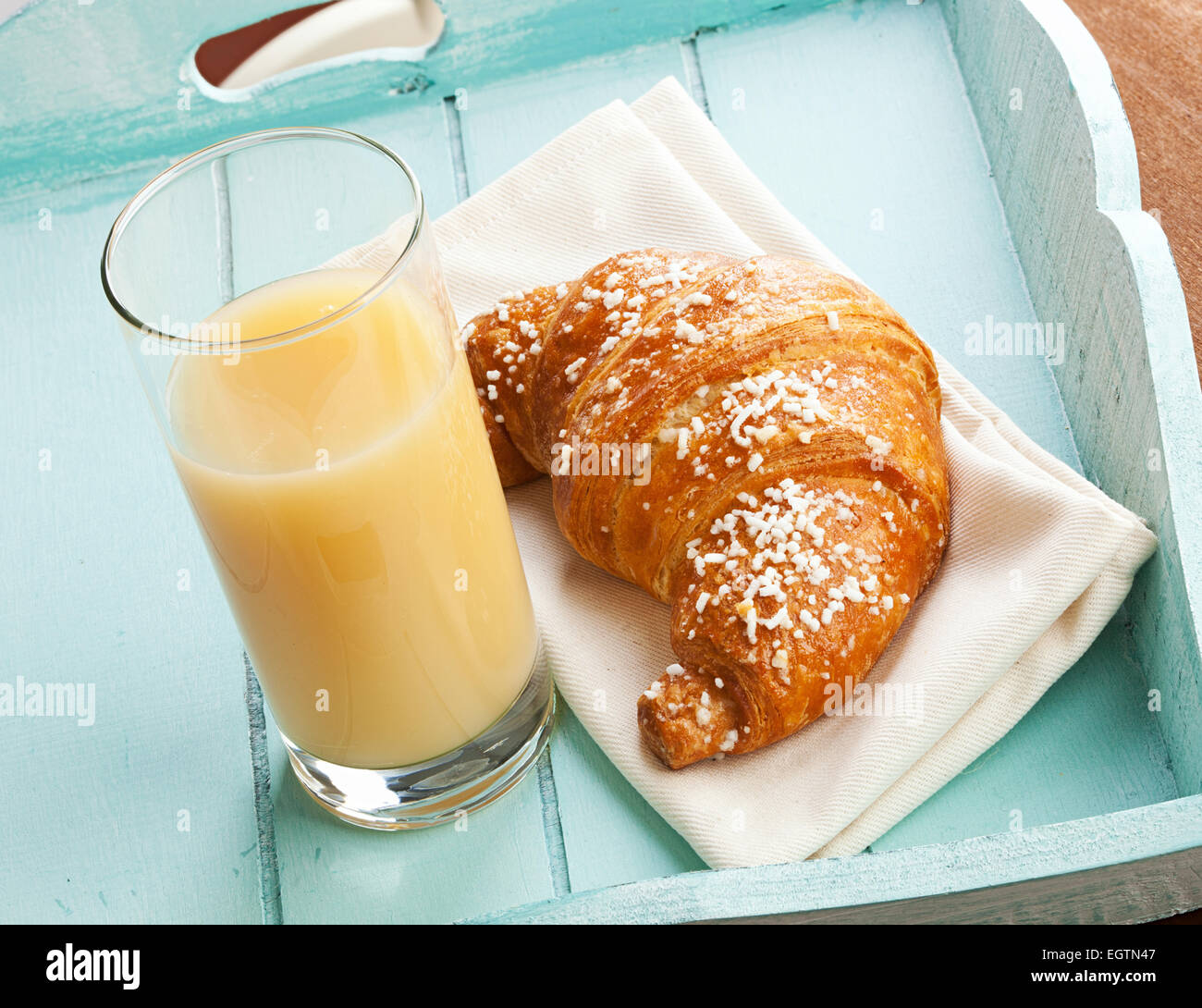Croissant et jus de poire sur le bleu clair. Banque D'Images