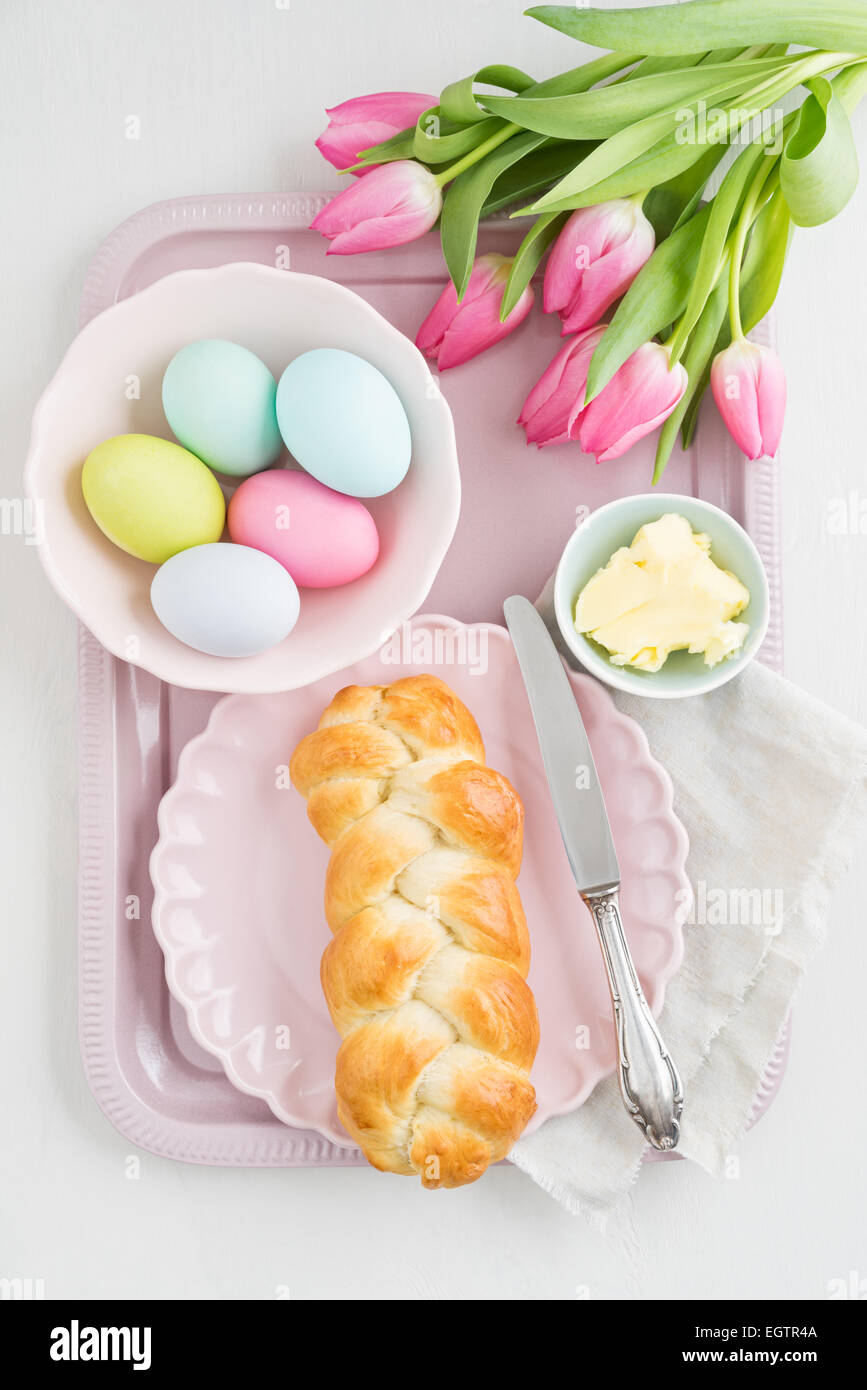 Table de petit-déjeuner de Pâques avec les oeufs de Pâques, tulipes et sweet pain tressé de levure Banque D'Images
