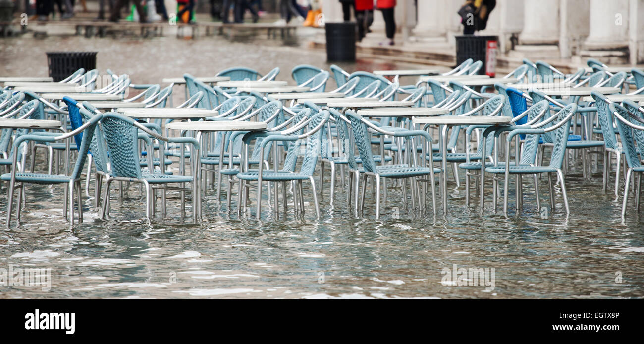 Des tables et des chaises avec de l'eau élevé dans la place Saint Marc, Venise, Italie. Banque D'Images