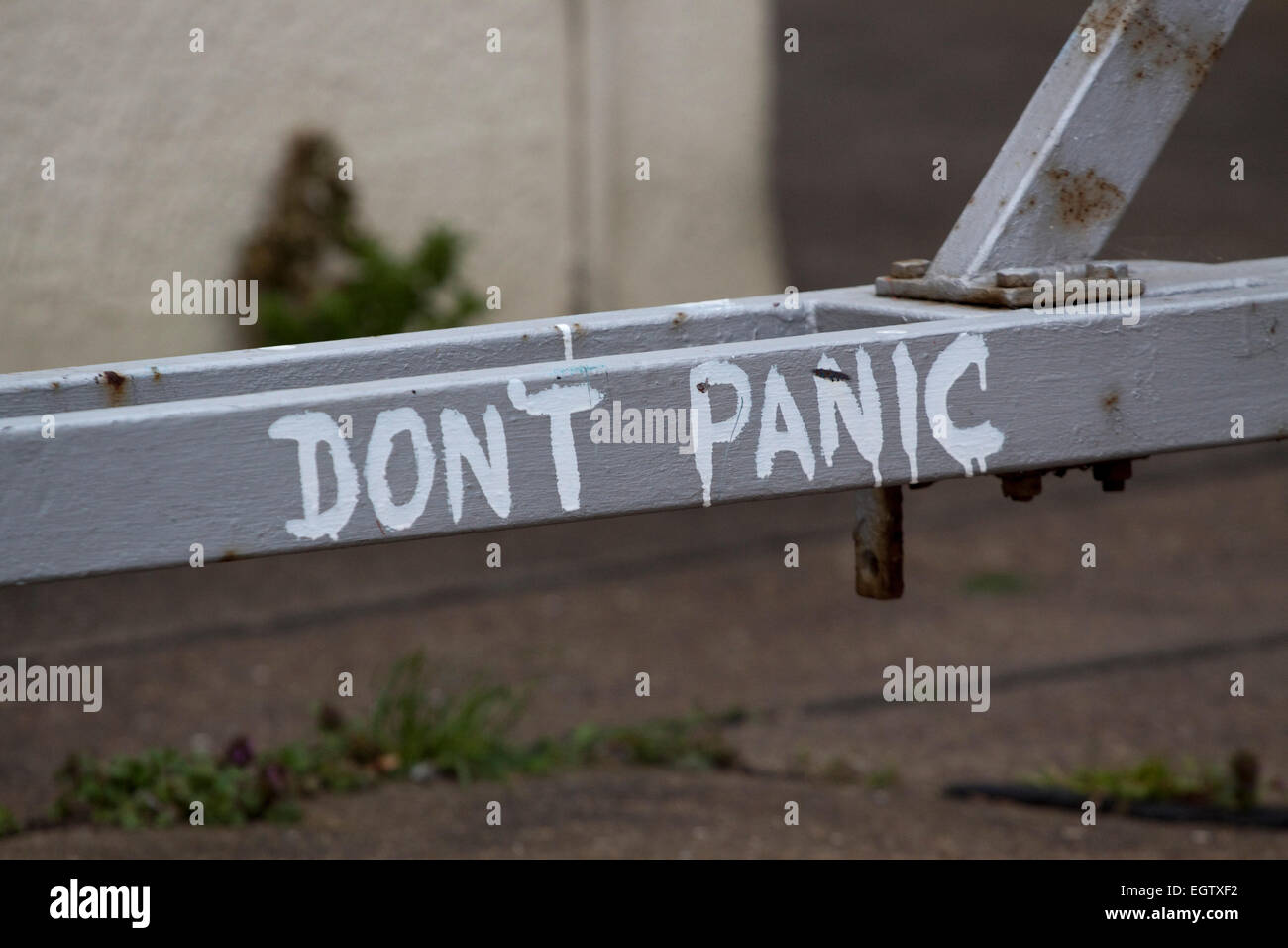 'DON'T PANIC' maladroitement peint en blanc la peinture qui a exécuté sur une barre de remorquage peints argent Banque D'Images