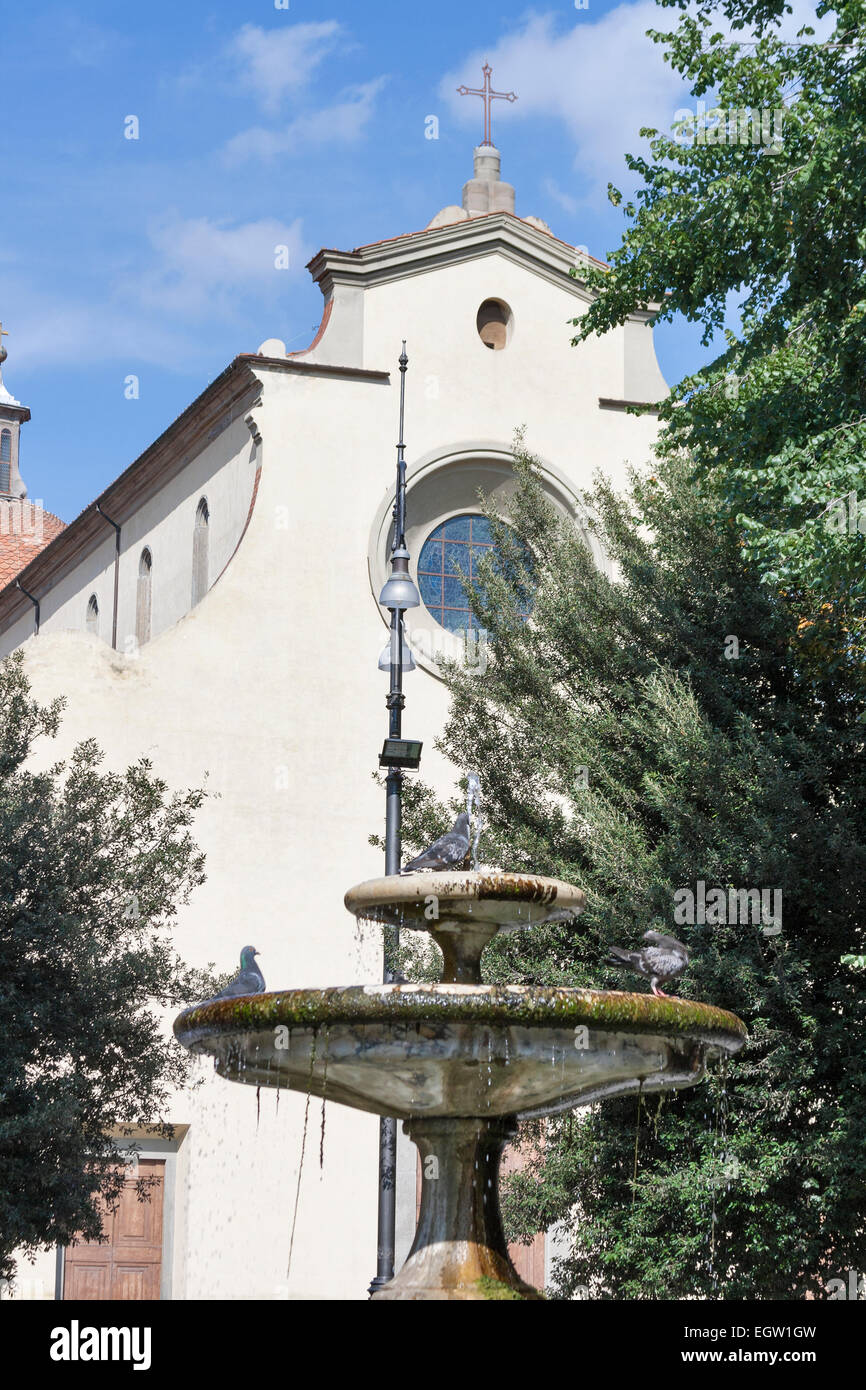 Petite fontaine en face de la basilique de l'Esprit Saint façade dans Florence, Italie Banque D'Images