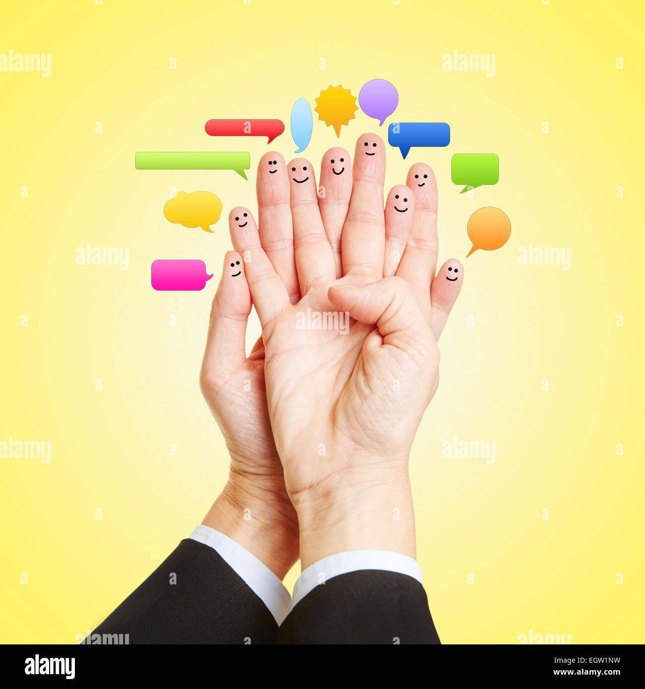 Les médias sociaux Chat avec de nombreux smileys sur les doigts des deux mains Banque D'Images Les médias sociaux Chat avec de nombreux smileys sur les doigts des deux mains Banque D'Images