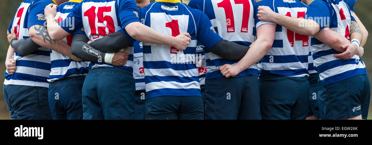 Les joueurs de rugby masculin câlin avec armes liés. Banque D'Images
