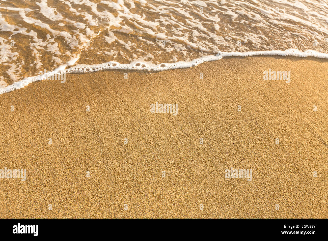 La texture de la mer plage de sable avec une douce vague de surf. Banque D'Images