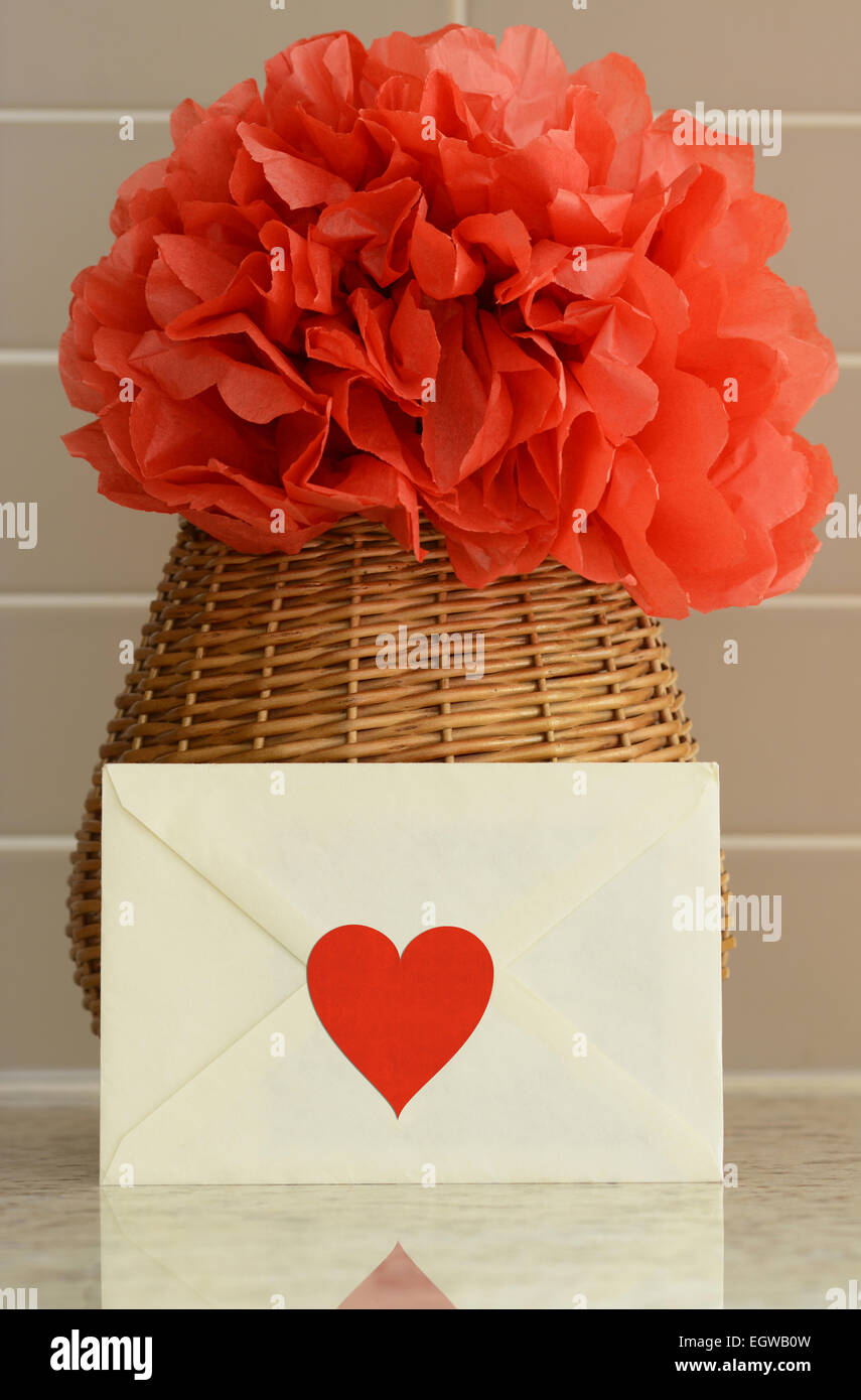 Panier Vase avec du papier rouge pom pom fleur et une lettre d'amour sur le comptoir de cuisine Banque D'Images