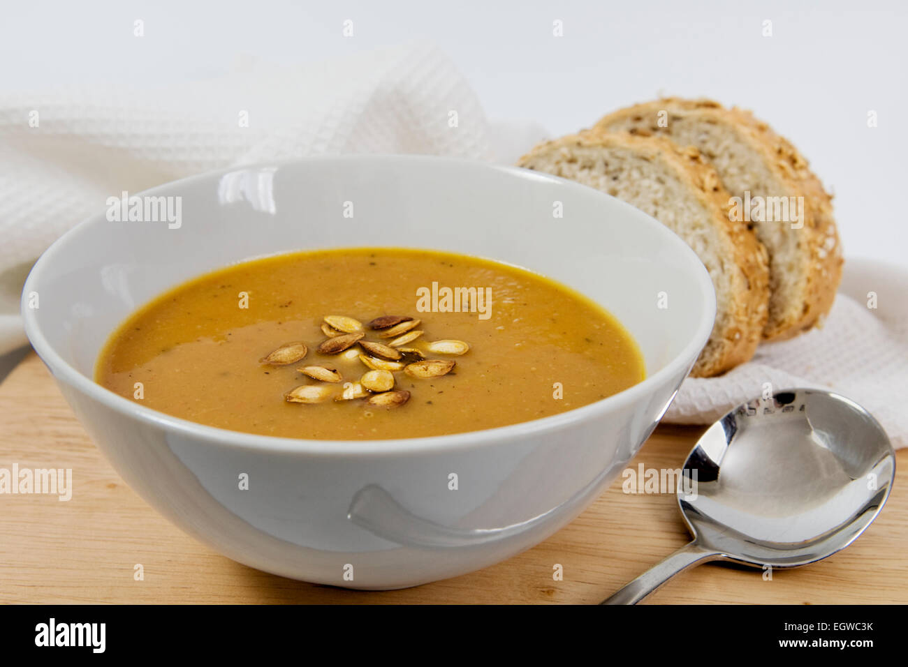 Rôti maison épicée potage à la courge musquée graines de courge grillées arrosé sur le dessus, dans un bol blanc Banque D'Images