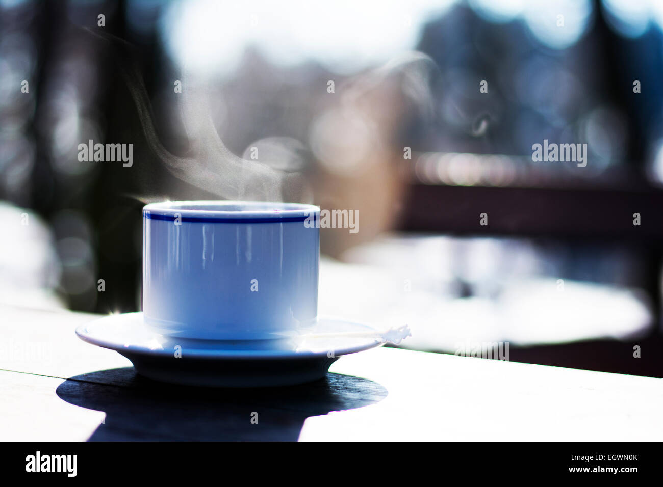 Tasse de café fumant sur la table en bois à l'extérieur Banque D'Images