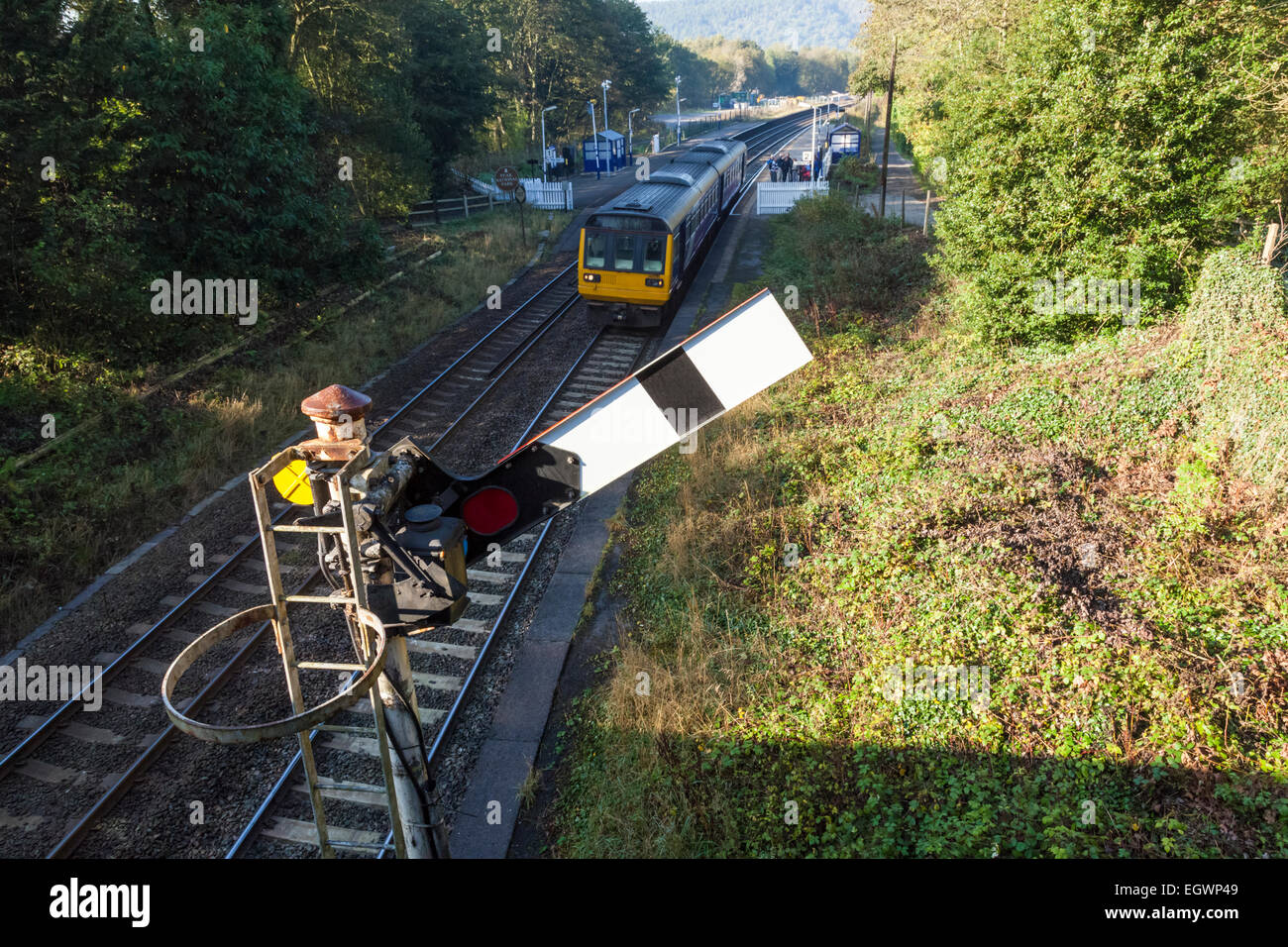 Northern Rail train approchant le sémaphore signal en clair à partir de la gare, Grindleford, Derbyshire Peak District National Park, Angleterre, RU Banque D'Images