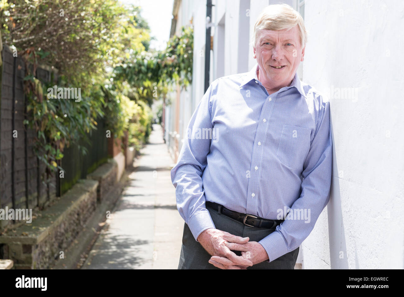 Un senior, homme d'affaires à la retraite pose devant sa voiture classique, murs, escalier et urbain autour de la ville, dans une chemise ouverte Banque D'Images