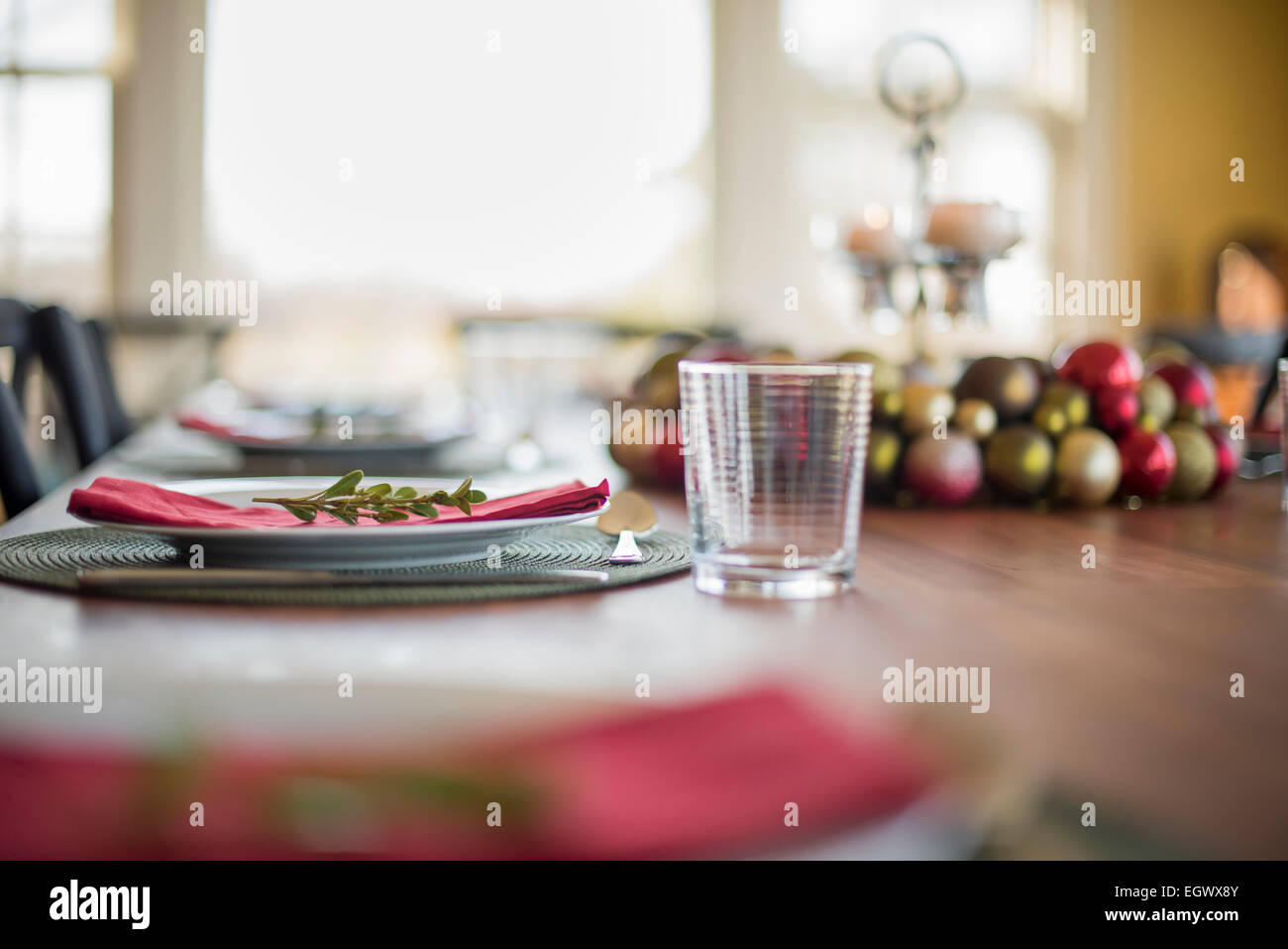 Une table dressée pour un repas de fête. Les boules de Noël, décorations et une bougie dans un bougeoir. Banque D'Images