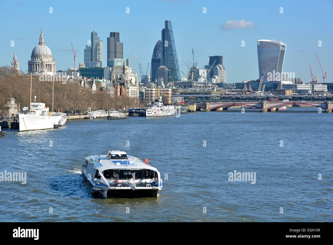 Thames Clipper catamaran grande vitesse de banlieue et le service de bus touristiques river avec Ville de toits de Londres au-delà England UK Banque D'Images