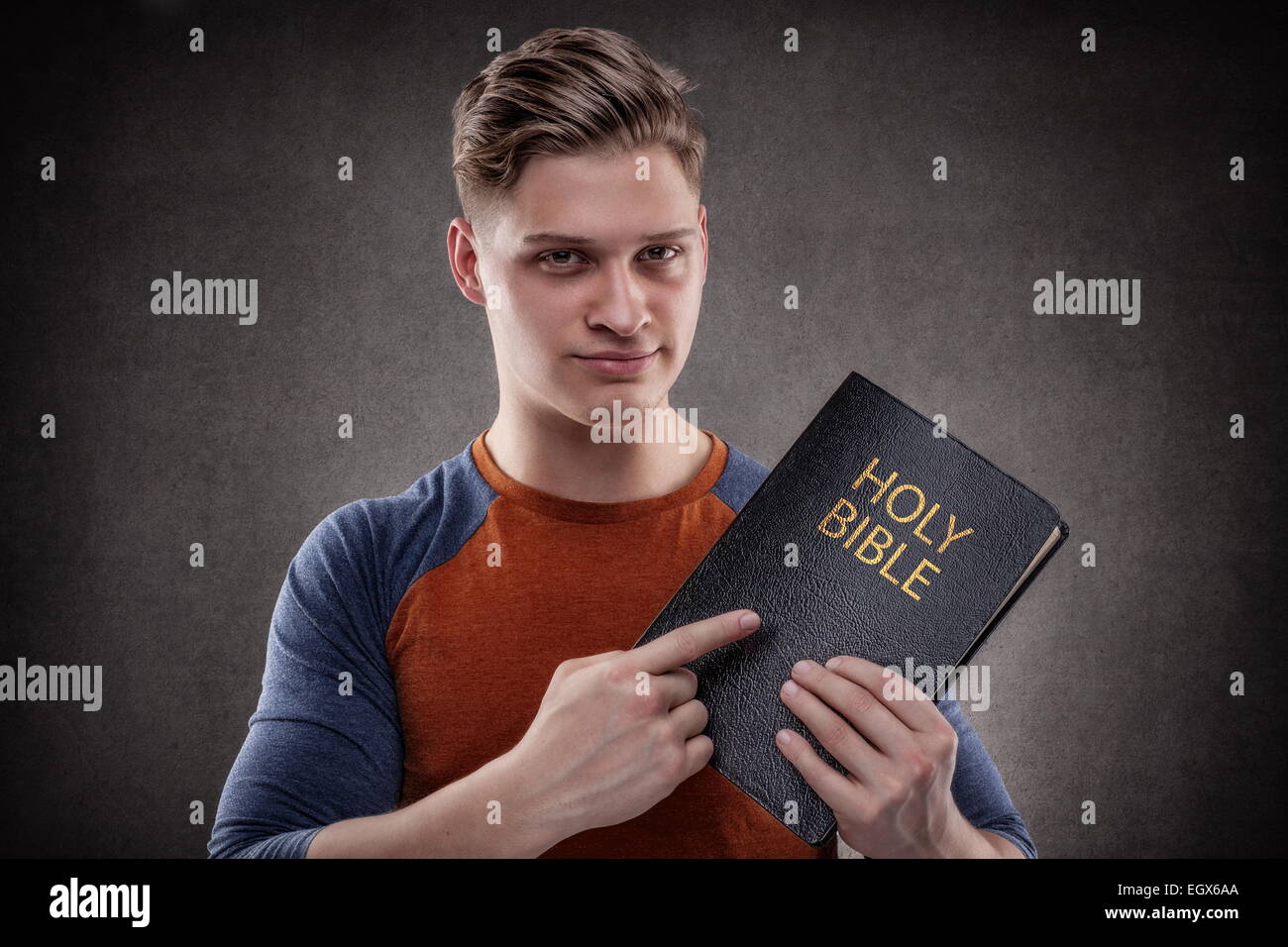 Heureux jeune homme pointant sa Sainte Bible avec cuir Banque D'Images