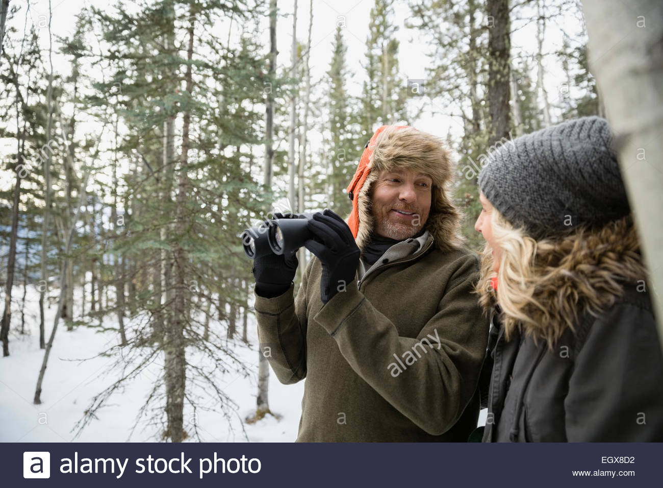 Couple avec des jumelles l'observation des oiseaux dans la région de Snowy Woods Banque D'Images