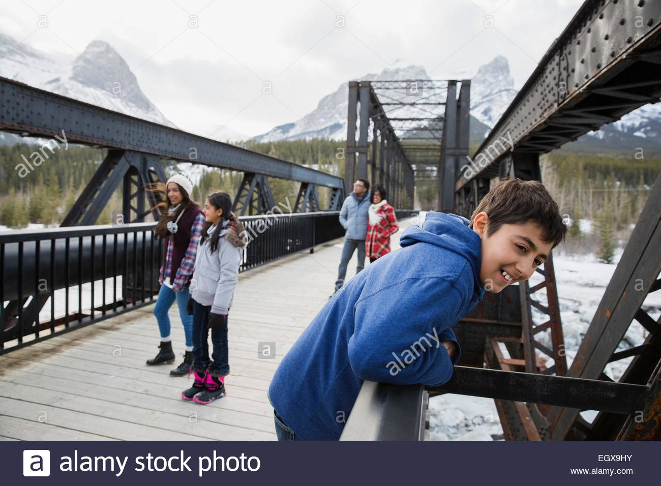 Pont sur la famille en dessous de montagnes enneigées Banque D'Images