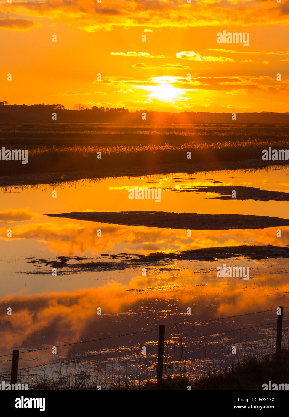 Marais de sel au coucher du soleil dans la mer, suivant le CLAJ North Norfolk, au Royaume-Uni. Banque D'Images