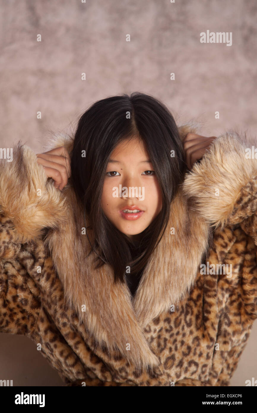 Belle fille chinoise, habillé avec un manteau ethnique, poser et jouer en face de la caméra. Banque D'Images