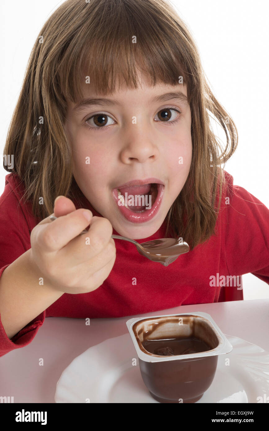 Petite fille manger une crème au chocolat isolé sur fond blanc Banque D'Images