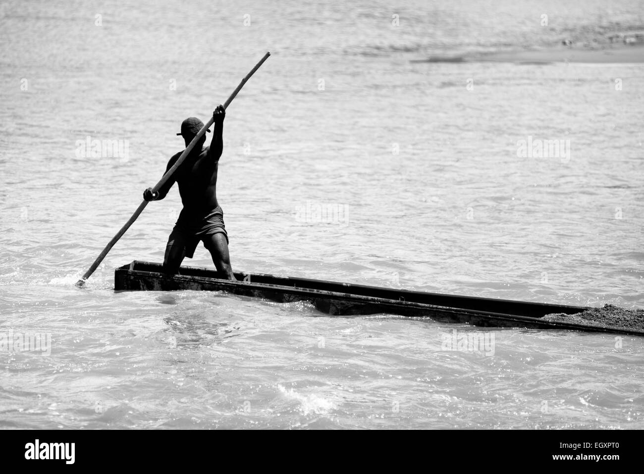 Un mineur, à l'aide d'un sable barge totémique, navigue sur son bateau chargé avec extrait du sable dans la rivière à Cartago, Colombie. Banque D'Images