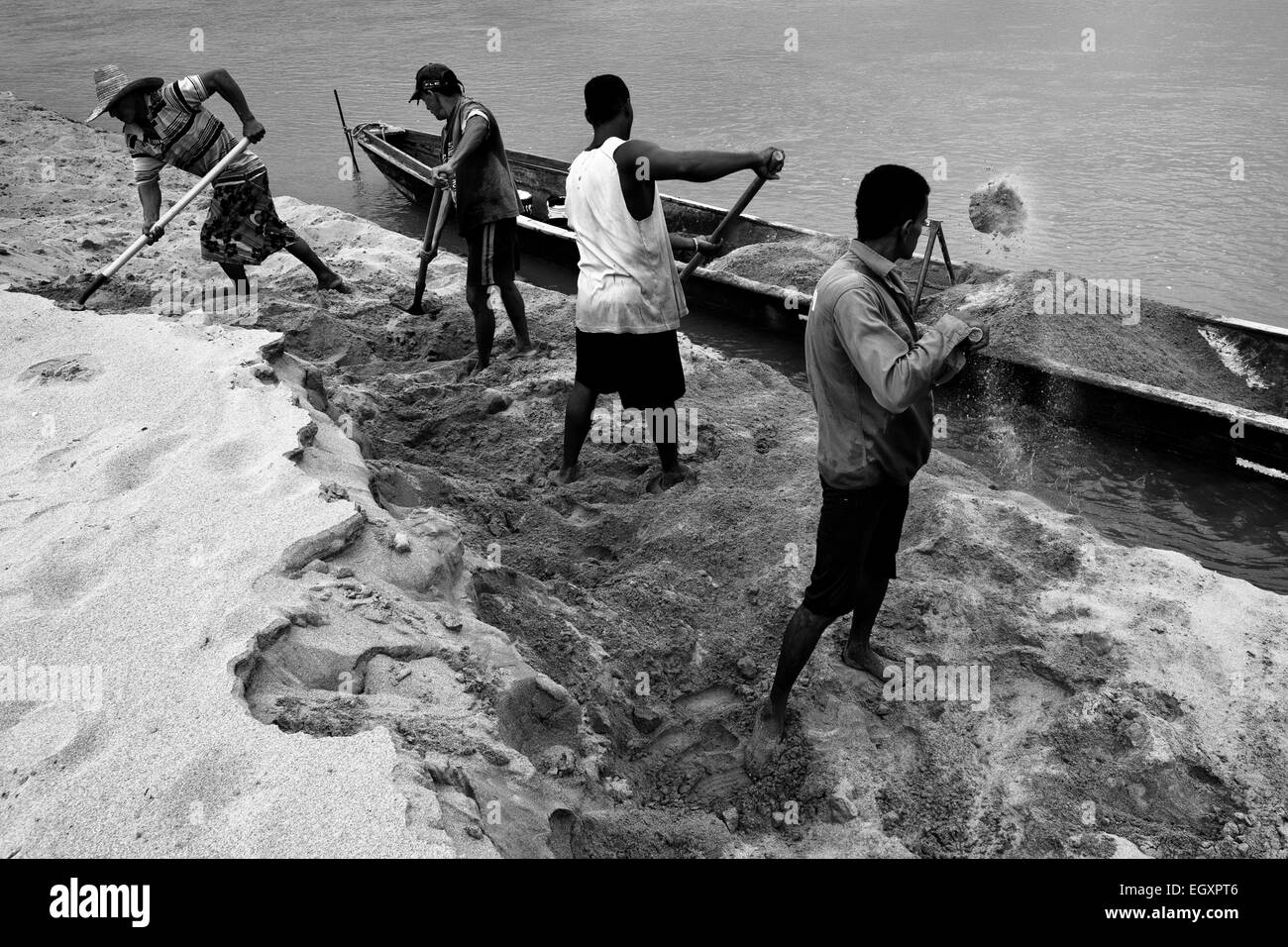 Sable colombien charge mineurs le sable dans un bateau sur la rive de la rivière Magdalena à Puerto Berrío, Colombie. Banque D'Images