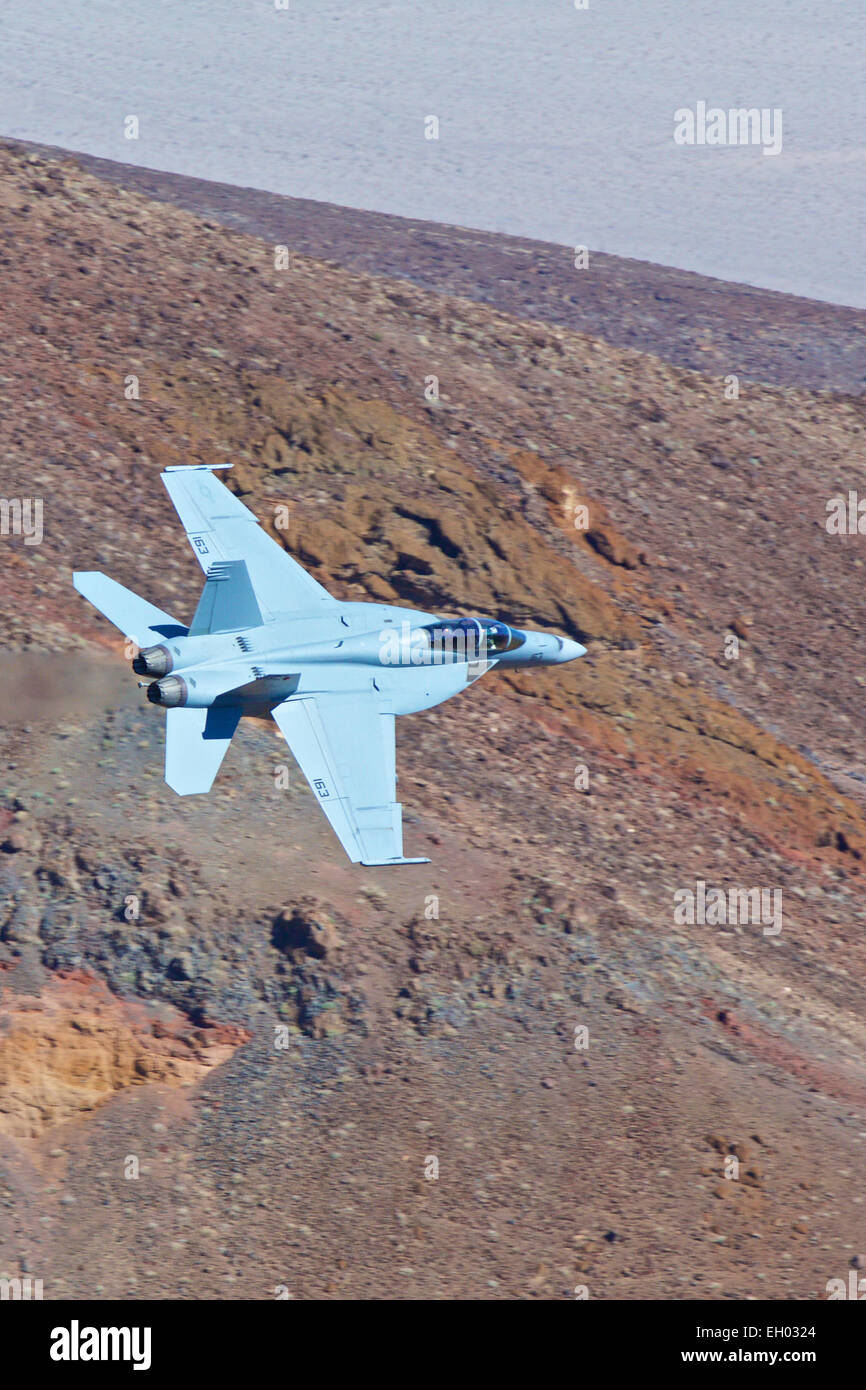 United States Navy F-18 Super Hornet, volant à basse altitude à travers un canyon désert. Banque D'Images