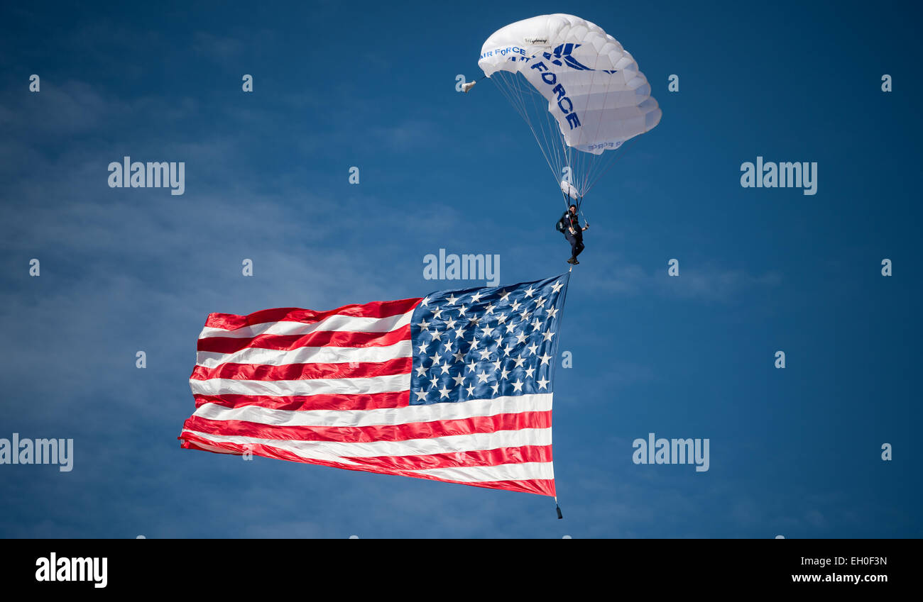 1ère classe Cadet Josh Burres, 98e Escadron d'entraînement au vol des ailes, un parachutiste bleu Greensboro, NC, les mouches indigènes les drapeau des États-Unis au cours d'une démonstration aérienne pour les cérémonies d'ouverture de l'Armée de l'air guerrier blessé (AFW2) 2015 Essais cliniques de la Nellis Air Force Base, NV, le 27 février. L'AFW2 Essais cliniques sont un événement sportif adapté visant à promouvoir le bien-être mental et physique des personnes gravement malades et blessés militaires et anciens combattants. Plus de 105 blessés, malades ou blessés, hommes et femmes de tout le pays seront en compétition pour une place dans l'US Air Force 2015 de l'équipe du guerrier blessé Banque D'Images