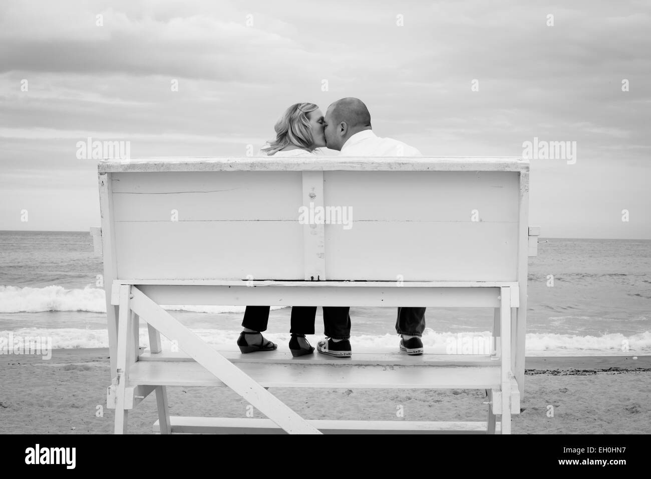 Couple amoureux, baiser sur la chaise du sauveteur à la plage Photo Stock -  Alamy